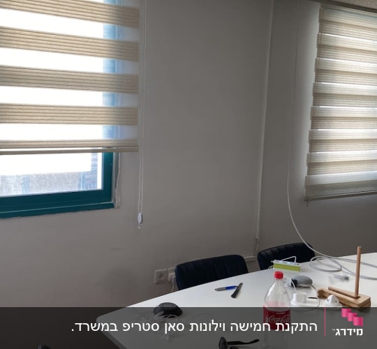 וילונות גלילה בהירים על חלונות במשרד